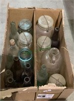 Large box of vintage glass bottles and jars.