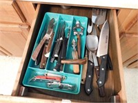 Drawer of kitchen utensils: knives, ice cream