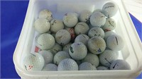 Bucket of assorted used golf balls