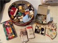 Round tin full of sewing supplies and notions