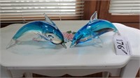 Two glass dolphins.
