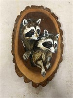 Adorable hand painted racoons on a piece of tree