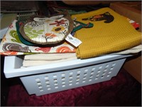 Basket full of dish towels and pot holders plus