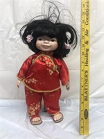 Oriental Doll w/red outfit on doll stand