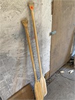 2 wooden boat paddles of different sizes