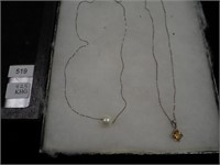 Two sterling chains, both with pendants, one is a