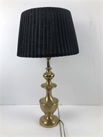 Tall brass lamp with a black pleated shade