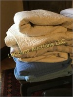 stack of queen comforters and old quilt