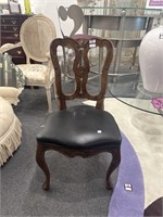 Carved wooden chair with black seat