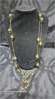 Extra long gold tone and green beaded necklace