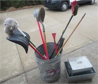 Metal garbage can with yard tools including