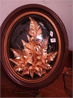 An oval framed wall hanging of 24K gold plated