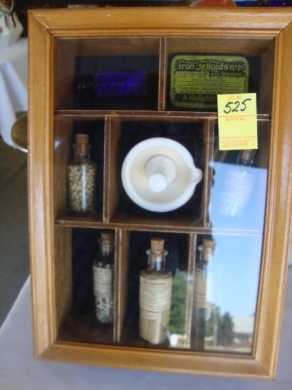 Cased wall display of old apothecary items.