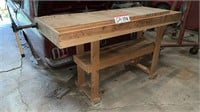 Wooden work bench with attached vise on left