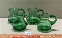 FOUR COLORED GREEN GLASS JUGS