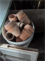 Bucket of small terracotta pots