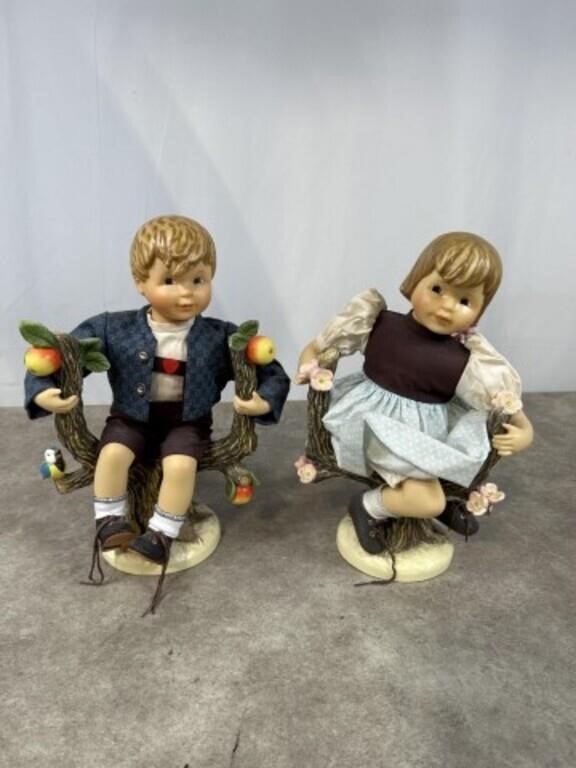 Hummel boy and girl figurines sitting in apple