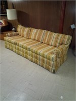 Vintage colorful couch located in basement bring