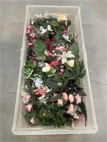 Artificial flowers and greenery in a Rubbermaid