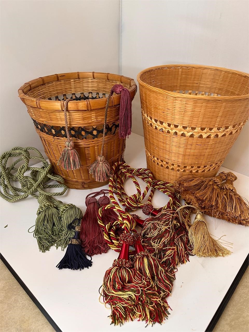 2 wicker trash baskets and tassle decor