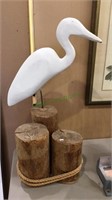 Large carved wood seabird on three wood pilings,