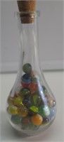 7" T GLASS  JAR FULL OF VINTAGE MARBLES. VERY