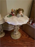 Marble top table with scalloped edges and cherub