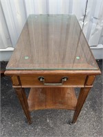 Accent table on casters with drawer and glass top