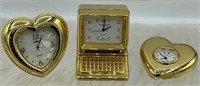 Miniature brass clocks, one of the hearts has a pe