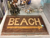 Metal beach sign, decorative fish, sea shells and