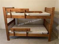 Oak twin bunk bed with mattresses and ladder