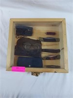Assorted pocket knives eyeglasses and showcase