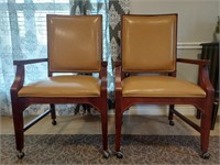 Pair of rolling wooden and faux leather chairs