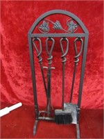 Wrought iron fire place tools on stand.