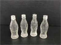 Four mini Coca-Cola bottles
