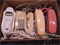 Box of vintage telephones including three colors