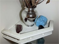 Contents on corner shelves in master bathroom glas