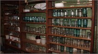 Contents of wdn shelves along wall including jars,