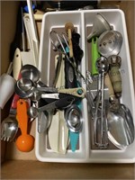Box of kitchen gadgets, knives, measuring spoons,