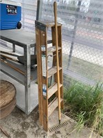 Lot with wooden ladder and a metal rake, ladder is
