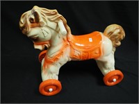 Toddler riding horse on wheels with handles,