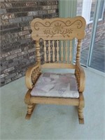 Oak rocking chair with floral design on the back