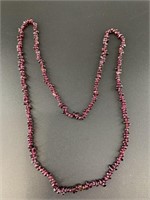 Long necklace of polished garnet beads.  31in circ
