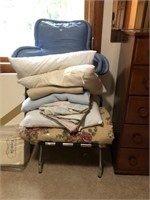 Blankets, pillows, suitcase stand and wedding