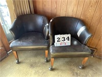 2 faux leather chairs on wheels