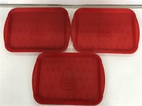 Three red Arby’s food trays