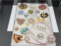 20 RHINESTONE BROOCHES AND ONE PINK BOLO TIE