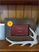 SHELF OF FRAMES AND ANTLERS