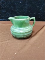 Green pottery pitcher with 121 marking on bottom
