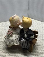 Newly Weds kissing on a bench by Napco